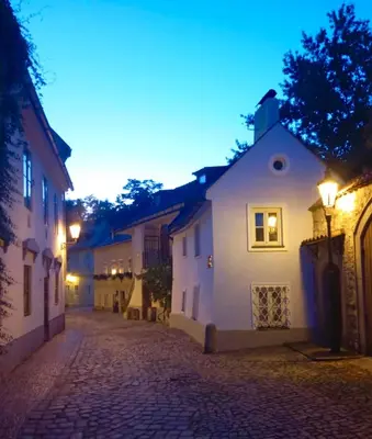 a cobblestone street in a town at night at Prague centrum apartment Hradčany in Prague