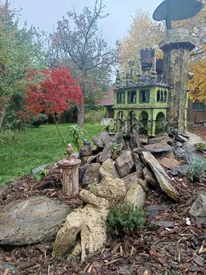 a garden in front of a house with a fountain at Strom času