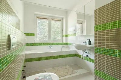 a green and white bathroom with a tub and a sink at Strom času