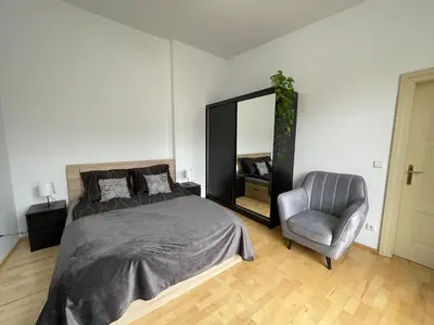 a bedroom with a bed and a chair and a mirror at Living in Prague 1 in Prague