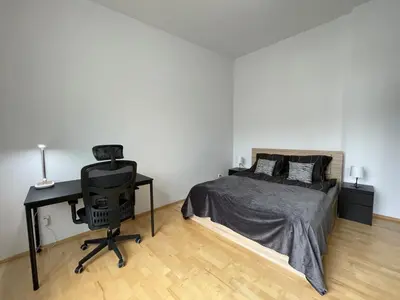 a bedroom with a bed and a desk with a computer at Living in Prague 1 in Prague