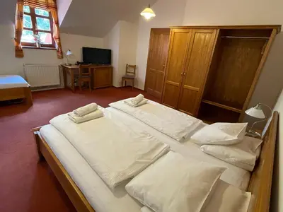 a bedroom with two beds with white sheets at Restaurace a Penzion U Labutě in Prague