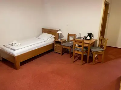 a bedroom with a bed and a table and chairs at Restaurace a Penzion U Labutě in Prague