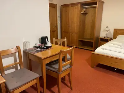 a room with a wooden table and chairs and a bed at Restaurace a Penzion U Labutě in Prague