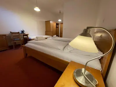 a bedroom with a bed with a lamp on a table at Restaurace a Penzion U Labutě in Prague