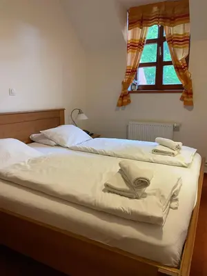 two beds with towels on top of them in a bedroom at Restaurace a Penzion U Labutě in Prague