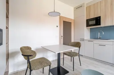 a kitchen with a white table and chairs at Blueground Nusle city view nr Vysehrad PRG-69 in Prague