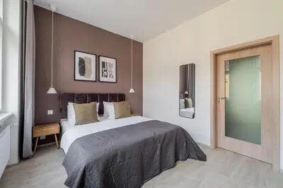 a bedroom with a large bed and a tv at Blueground Nusle balcony nr Vysehrad PRG-72 in Prague