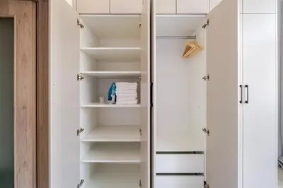 a walk in closet with white cabinets and shelves at Blueground Nusle balcony nr Vysehrad PRG-72 in Prague