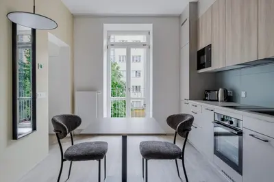 a kitchen with a table and two chairs at Blueground Nusle balcony nr Vysehrad PRG-72 in Prague