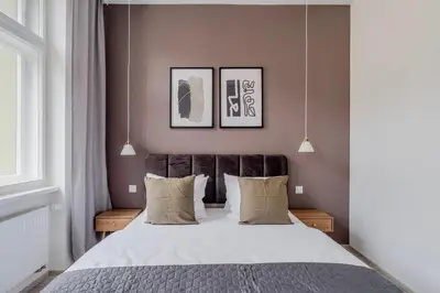 a bedroom with a large bed with two pictures on the wall at Blueground Nusle balcony nr Vysehrad PRG-72 in Prague