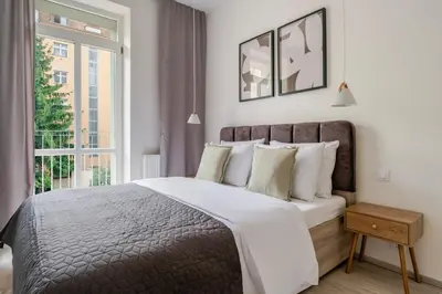 a bedroom with a large bed and a window at Blueground Nusle balcony nr Vysehrad PRG-64 in Prague