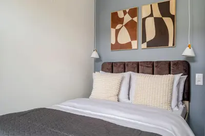 a bedroom with a bed with two paintings on the wall at Blueground Nusle view nr Vyšehrad PRG-70 in Prague