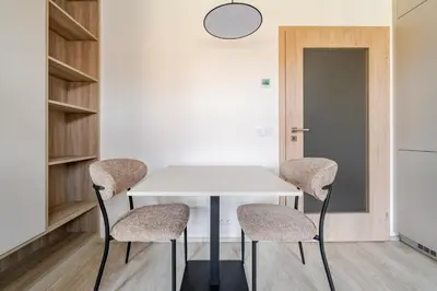 a white table with three chairs in a room at Blueground Nusle view nr Vyšehrad PRG-70 in Prague