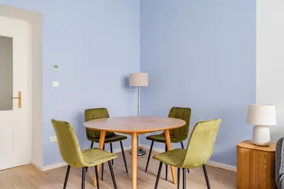 a table and chairs in a room with a lamp at Blueground Vinohrady balcony nr Riegrovy Sady PRG-78 in Prague