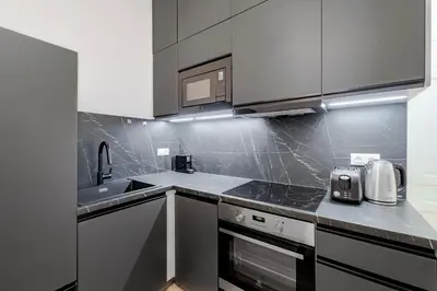 a kitchen with a sink and a stove top oven at Blueground Vinohrady balcony nr Riegrovy Sady PRG-78 in Prague
