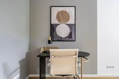 a desk with a chair and a picture on the wall at Blueground Vinohrady balcony nr Riegrovy Sady PRG-78 in Prague