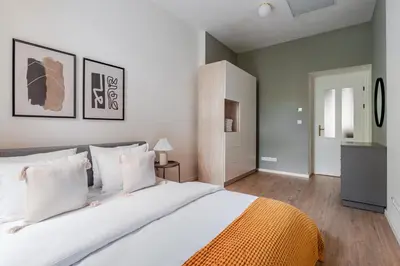 a bedroom with a large white bed with white pillows at Blueground Vinohrady balcony nr Riegrovy Sady PRG-78 in Prague