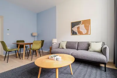 a living room with a couch and a table at Blueground Vinohrady balcony nr Riegrovy Sady PRG-78 in Prague