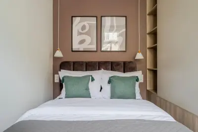 a bedroom with a large bed with green pillows at Blueground Nusle city view nr Vysehrad PRG-62 in Prague