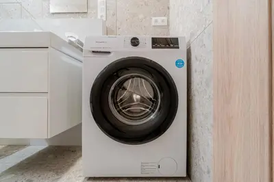 a white washing machine in a kitchen next to a counter at Blueground Nusle city view nr Vysehrad PRG-62 in Prague
