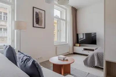 a white living room with a couch and a tv at Blueground Nusle city view nr Vysehrad PRG-62 in Prague