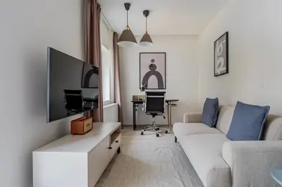 a living room with a couch and a tv at Blueground Nusle balcony nr Vysehrad PRG-67 in Prague