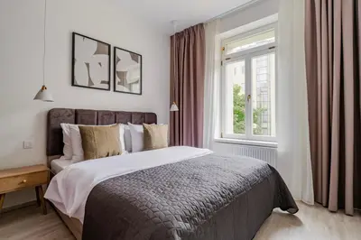 a bedroom with a large bed and a window at Blueground Nusle balcony nr Vysehrad PRG-67 in Prague