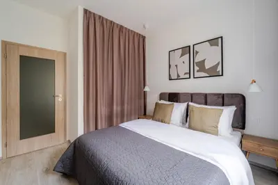 a bedroom with a large bed and a large window at Blueground Nusle balcony nr Vysehrad PRG-67 in Prague