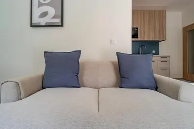 a couch with two blue pillows in a living room at Blueground Nusle balcony nr Vysehrad PRG-67 in Prague