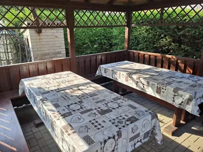 two picnic tables on a screened in porch with at H apartment in Jankov