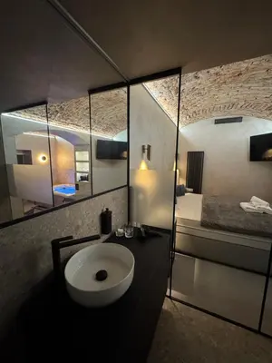 a bathroom with a sink and a bed and a mirror at SPA SPA Karlín in Prague