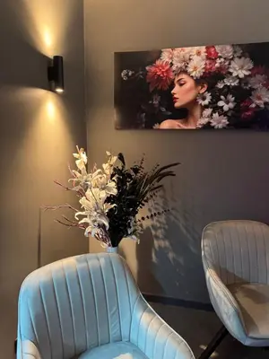 a room with a blue chair and a vase with flowers at SPA SPA Karlín in Prague