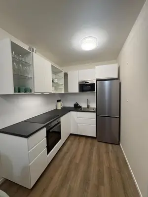 a kitchen with white cabinets and a stainless steel refrigerator at New Apartment Prague 5 in Prague