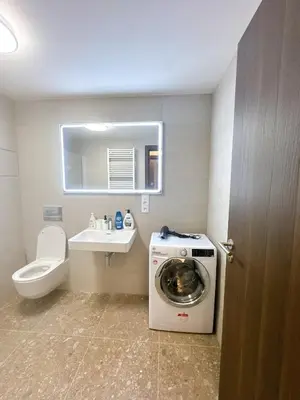 a bathroom with a washing machine and a sink at New Apartment Prague 5 in Prague