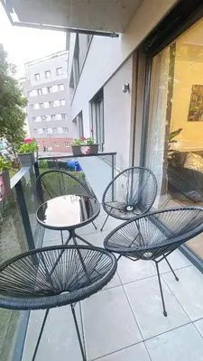 three chairs and a table on a balcony at New Apartment Prague 5 in Prague