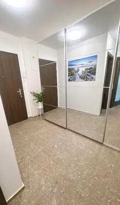 a large mirror in a room with a bathroom at New Apartment Prague 5 in Prague