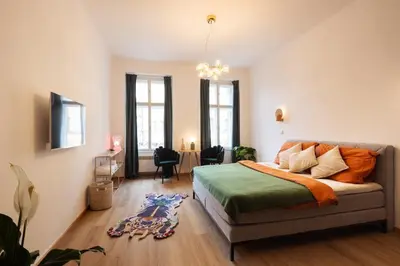 a bed with an orange blanket and white pillows at Prague Jungle Studio in Prague