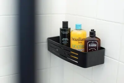 a shelf in a bathroom with bottles of soap and alcohol at Prague Jungle Studio in Prague