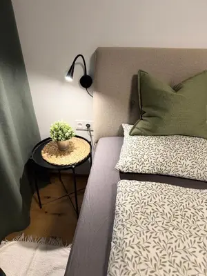 a bed with a side table with a plant on it at Prague Bohemian Grey in Prague