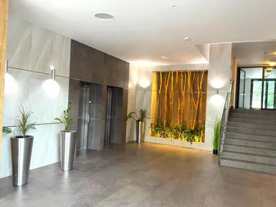a lobby with stairs and plants in a building at Garden Residence Terrace Apartment in Prague