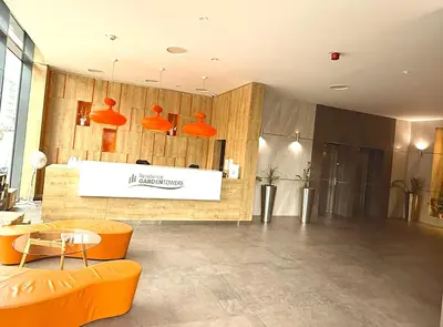 a lobby with orange chairs and a counter in a building at Garden Residence Terrace Apartment in Prague