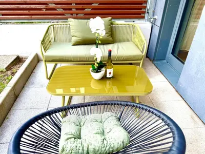 a patio with a table and a couch and a bottle of wine at Garden Residence Terrace Apartment in Prague