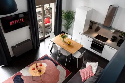 a living room with a table and a kitchen at Spacious loft-aparts on Karlin in Prague