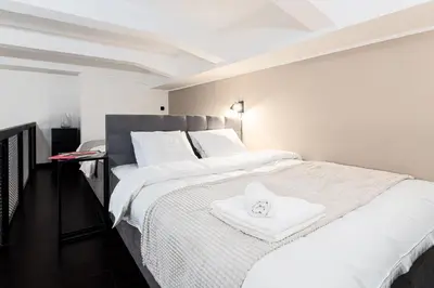 a bedroom with a large white bed with a towel on it at Spacious loft-aparts on Karlin in Prague
