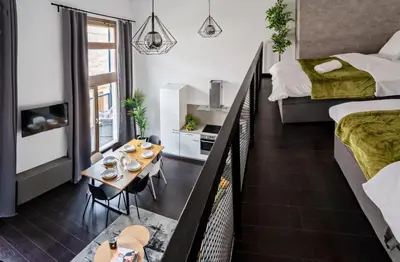 a small apartment with two beds and a table in a room at Spacious loft-aparts on Karlin in Prague