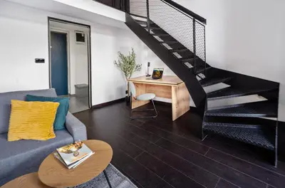 a living room with a couch and a staircase at Spacious loft-aparts on Karlin in Prague