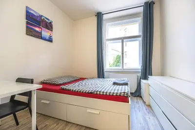 a small bedroom with a bed and a window at Apartment Velehradska in Prague