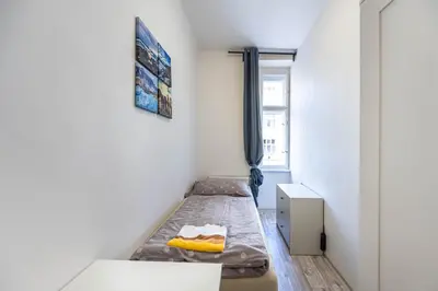 a small room with two beds and a window at Apartment Velehradska in Prague
