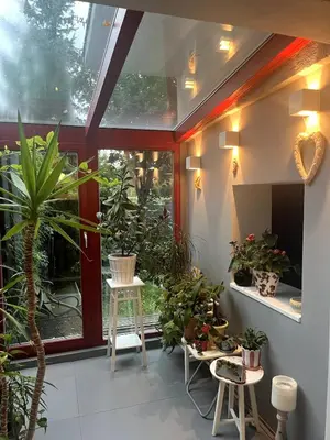 a conservatory with potted plants and a window at Prague Cozy Hideaway in Lysolaje